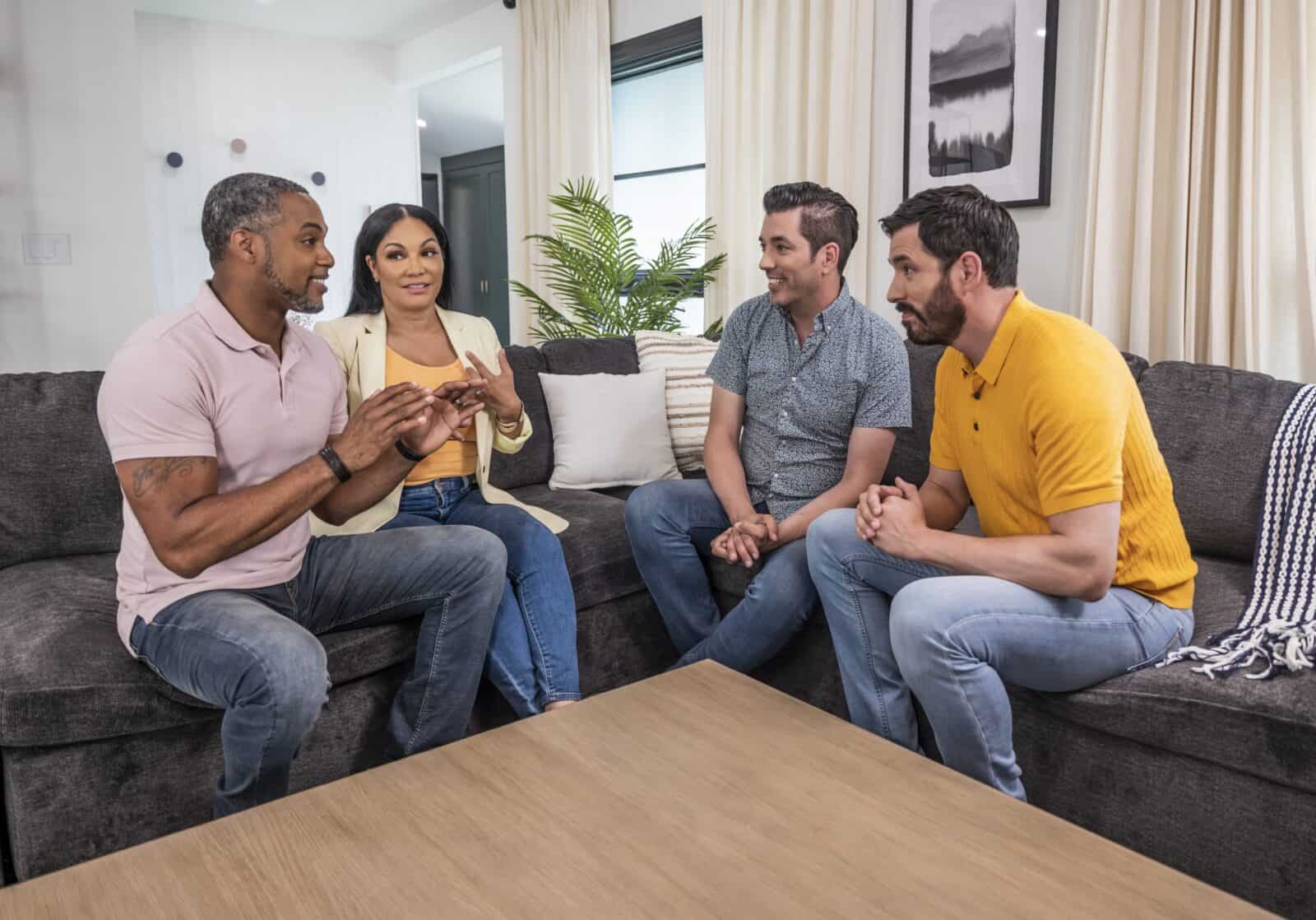 Drew and Jonathan Scott sitting with a couple in a cozy living room, having a conversation